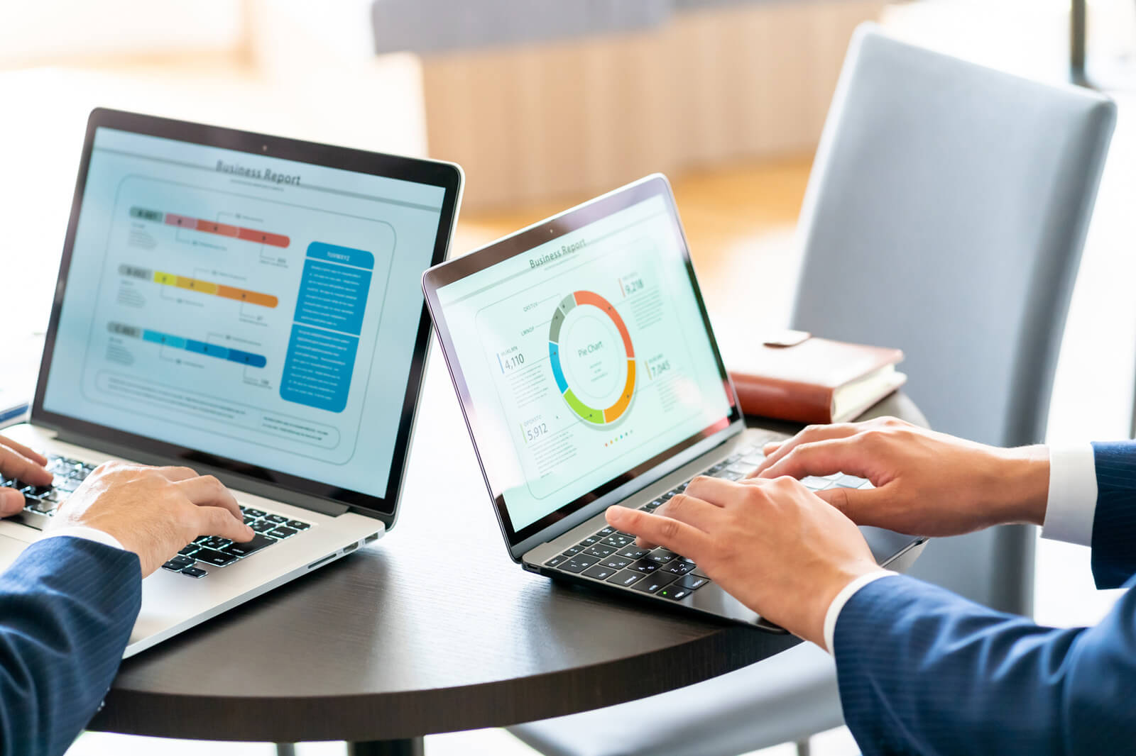 PCに表示された資料を見ながら作業する2人のビジネスパーソン