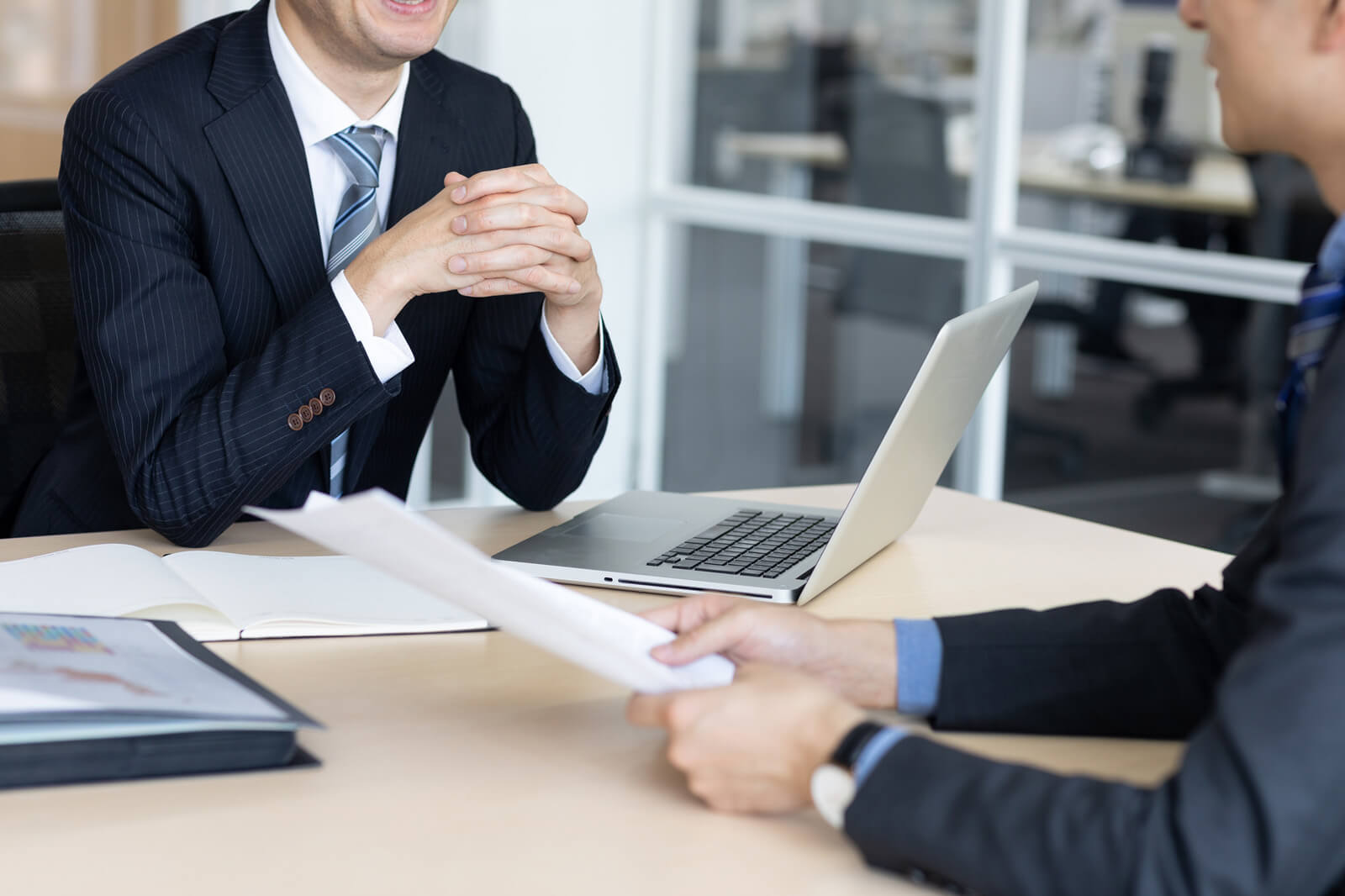 資料を見ながら商談している人